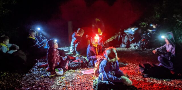 A group of scouts on a night navigation exercise stopped for a break